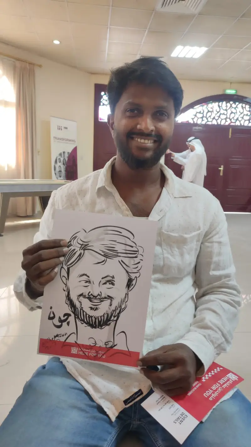 Guest holding the black ink caricature a caricature artist drew of him at a corporate staff event