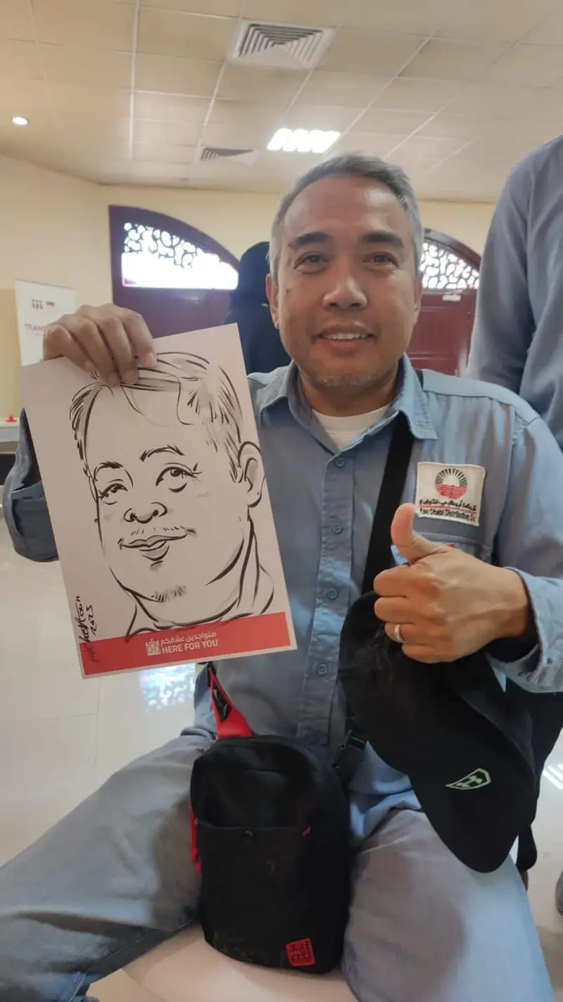 Smiling guest giving a thumbs up next to his black ink caricature at a corporate event